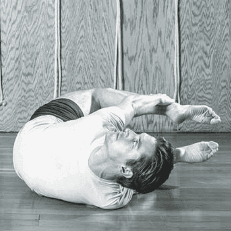 A man is laying on the floor doing yoga