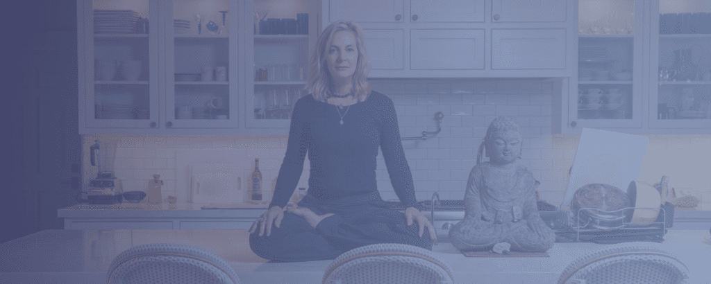 A woman sitting in the middle of a kitchen.