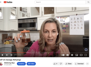 A woman holding up a jar in front of her face.