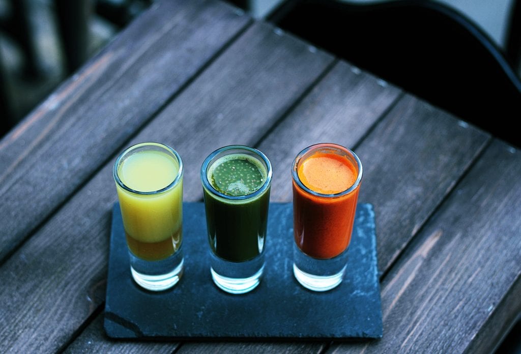 Three glasses of juice are on a table.