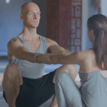 A man and woman sitting in the middle of a yoga class.