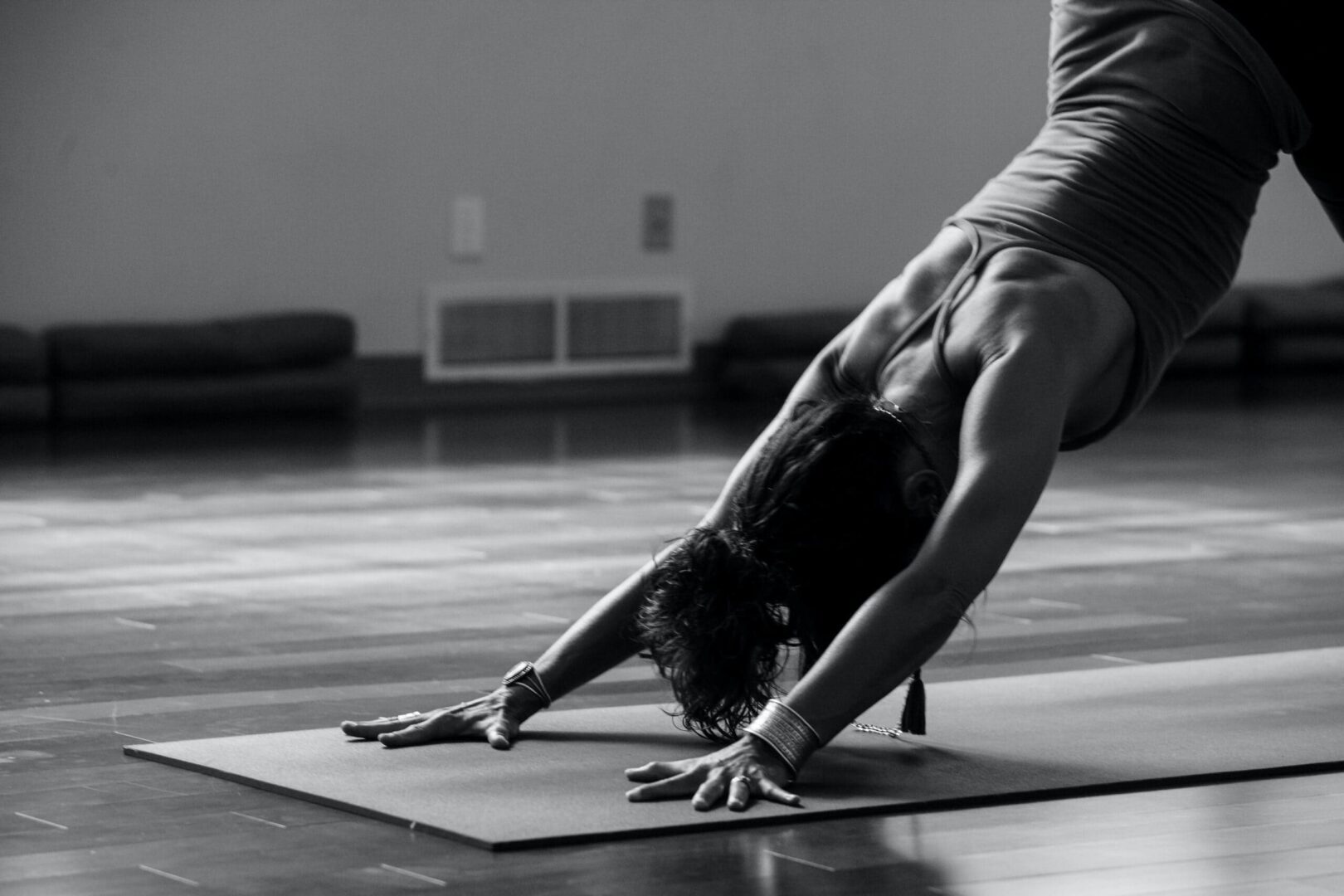 A man doing yoga on the floor in a gym.