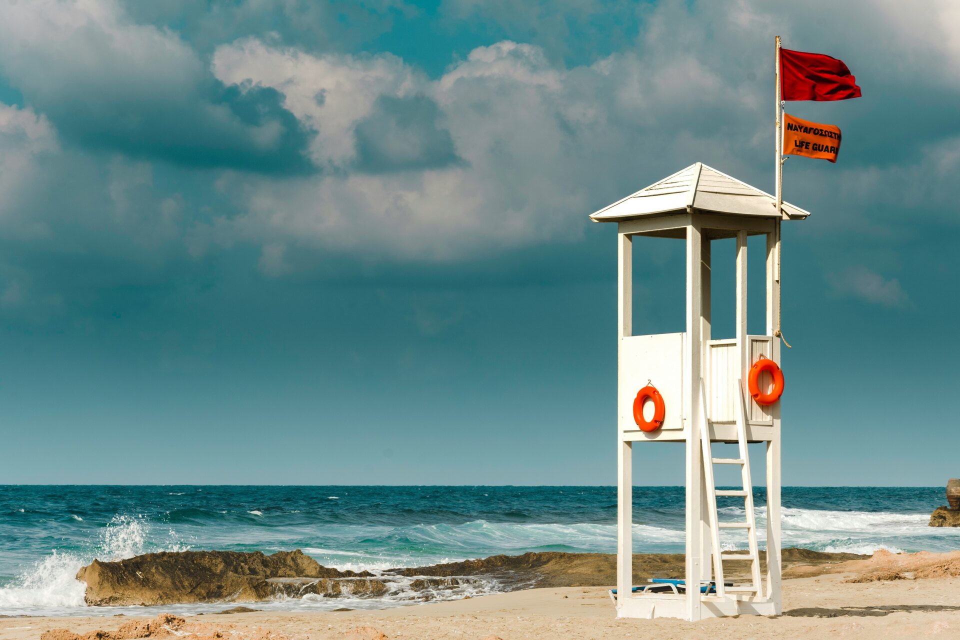 Lifeguard watching the ocean from a tower on a sunny day.